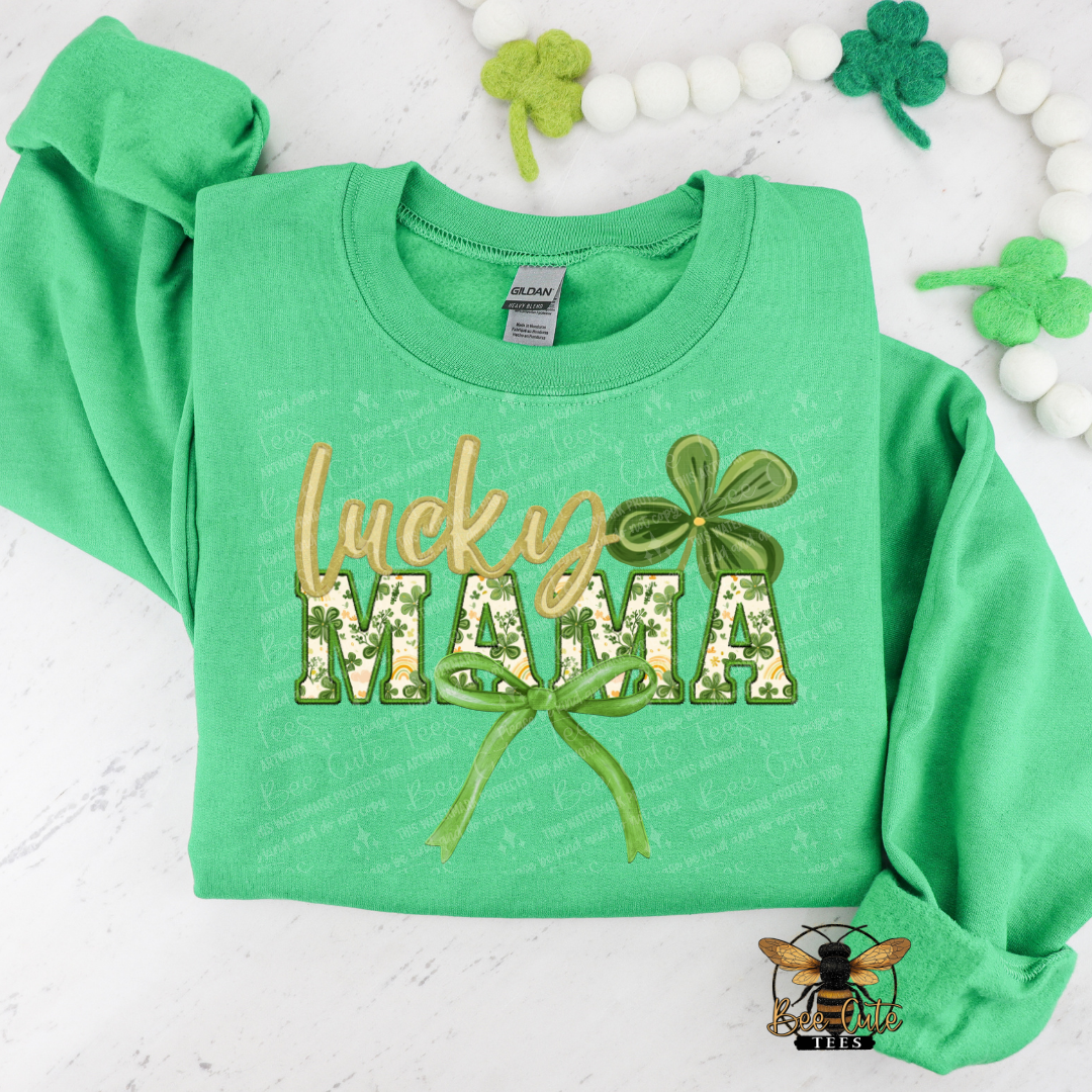 Green sweatshirt with 'Lucky Mama' text and shamrock design on a white background with decorative elements.