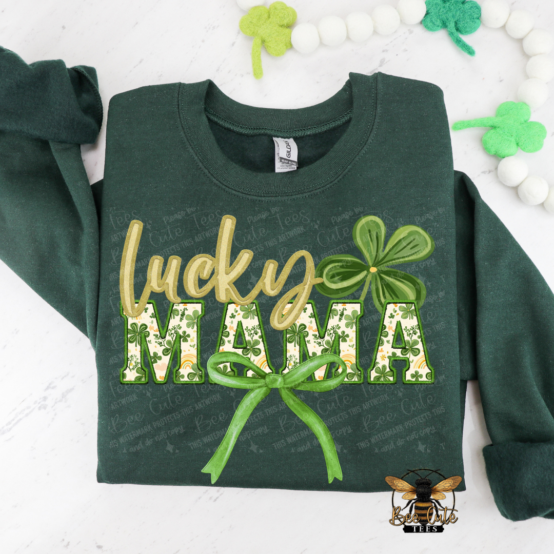 Green sweatshirt with 'Lucky Mama' text and clover design on a white background with decorative elements.