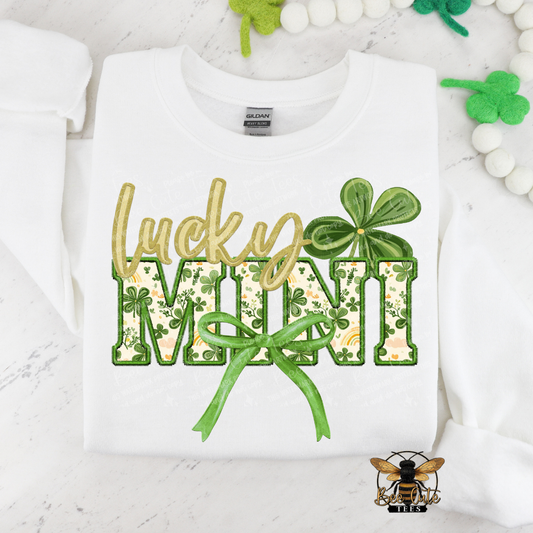 White sweatshirt with 'Lucky Mini' text and shamrock design on a white background