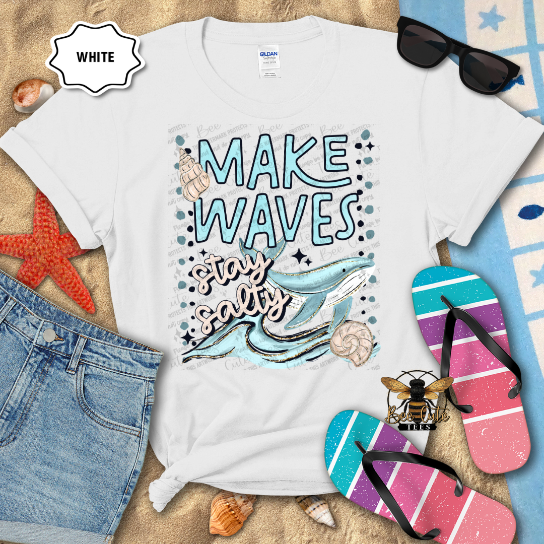 White t-shirt with 'Make Waves, Stay Salty' design on a beach-themed background with sunglasses, flip-flops, and starfish.