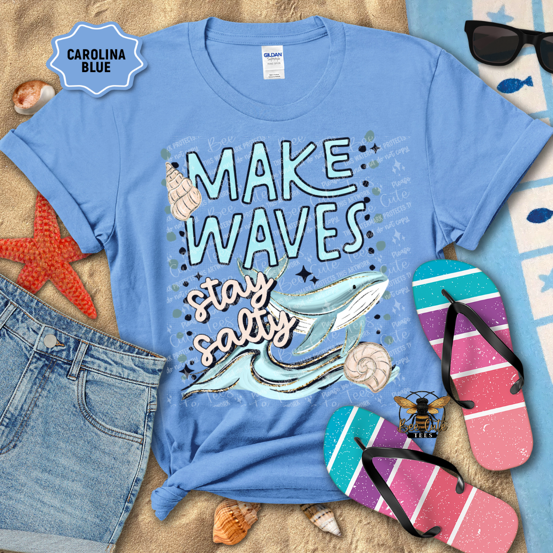 Blue t-shirt with 'Make Waves, Stay Salty' design on a beach-themed background
