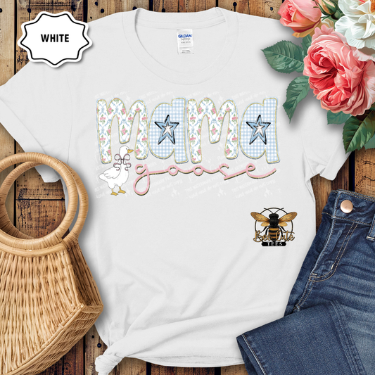 White t-shirt with 'Mama' design on a wooden surface with flowers and jeans.