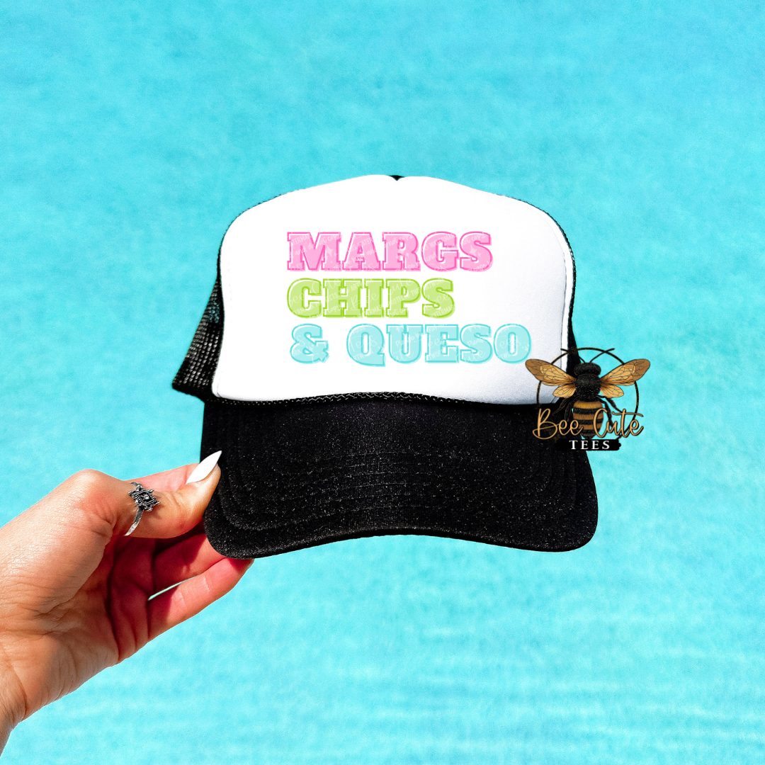 Trucker hat with 'MARGS CHIPS & QUESO' text held by a hand against a blue background