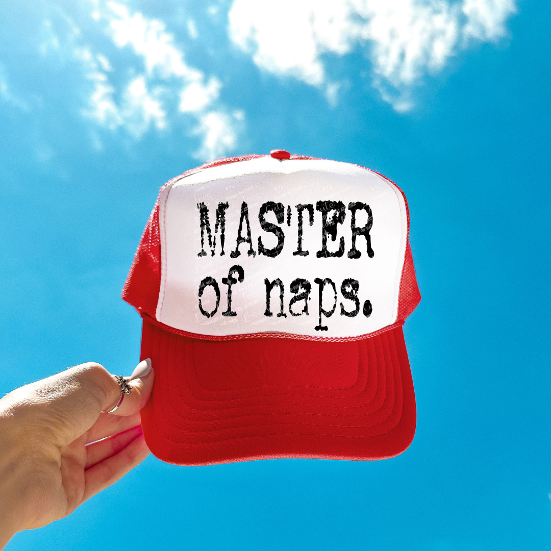 Red and white cap with 'Master of naps' text against a blue sky