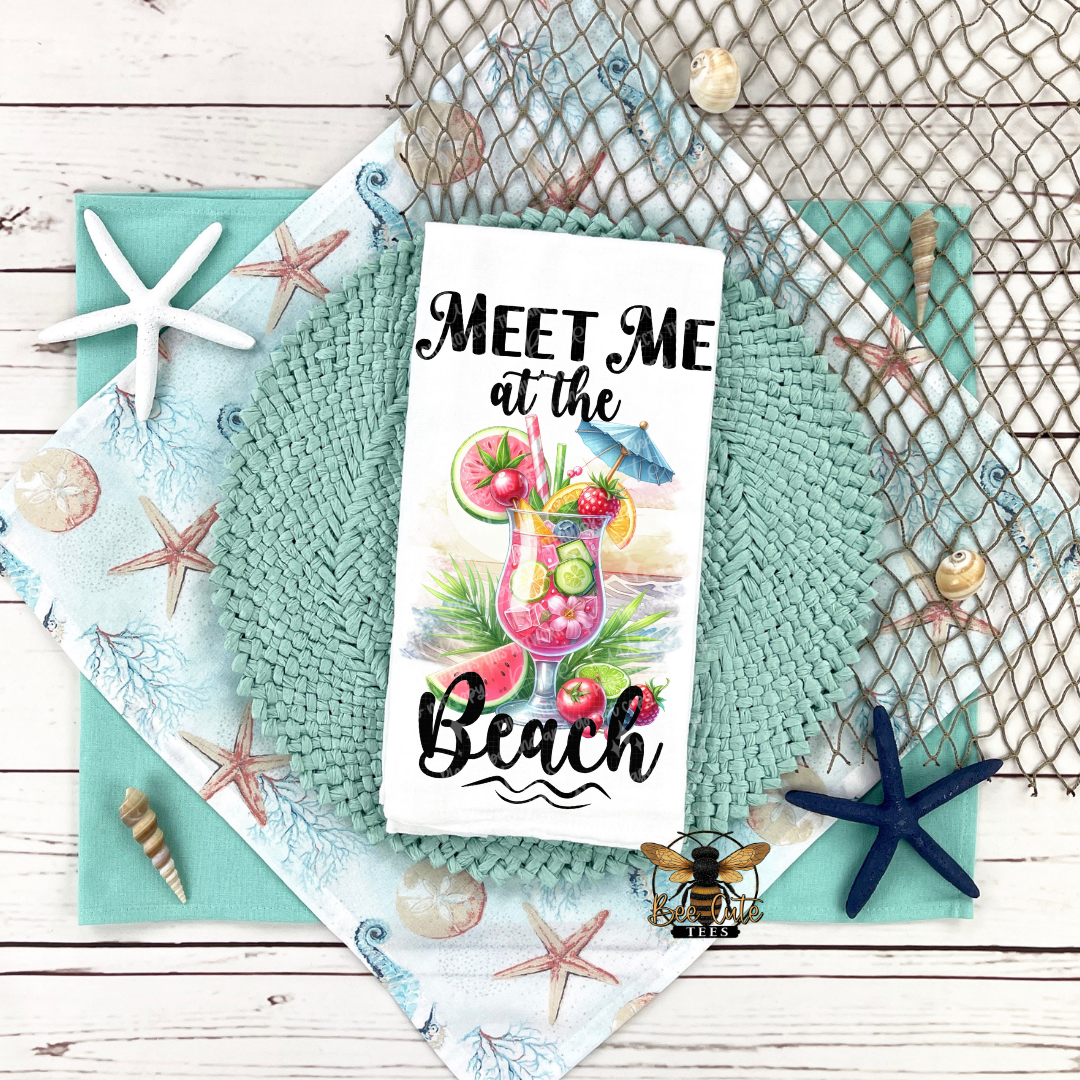 Tea towel with beach-themed design and text 'Meet Me at the Beach' on a decorative background.