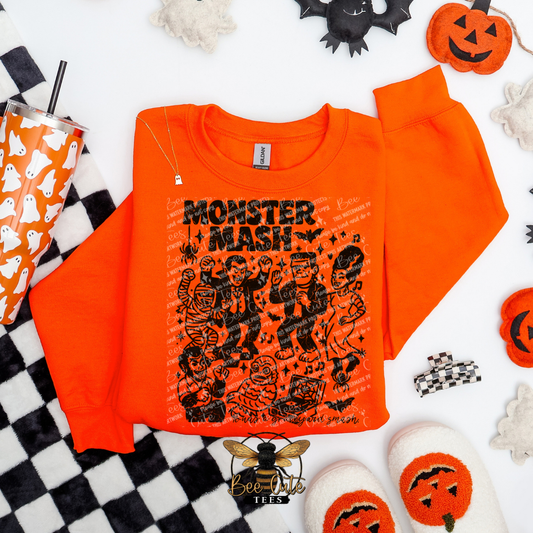 Orange sweatshirt with 'Monster Mash' design on a Halloween-themed background