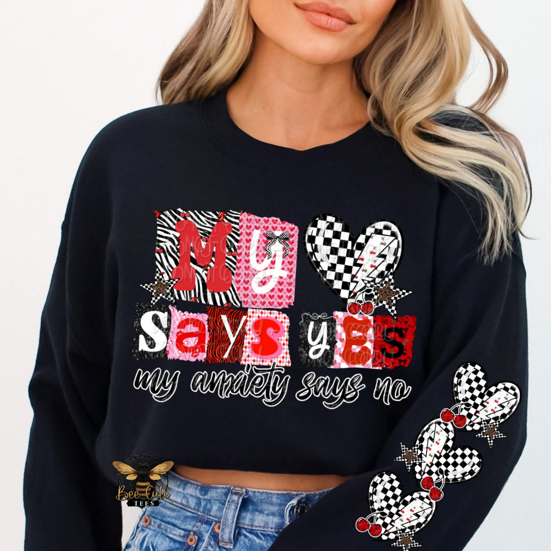 Black sweatshirt with colorful text and graphics worn by a person on a white background