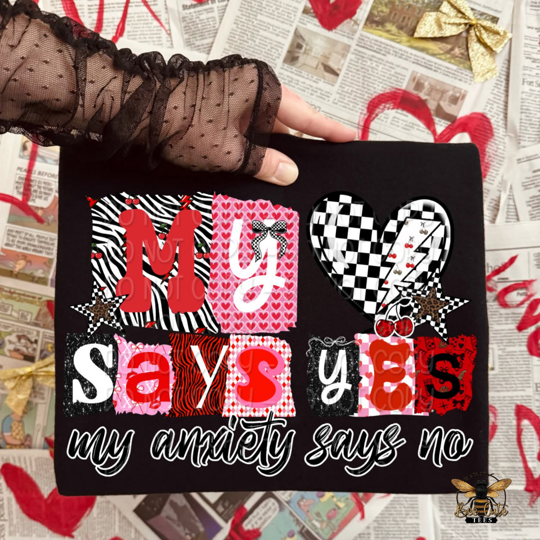 Black gloved hand holding a black t-shirt with colorful text and graphics on a newspaper background.