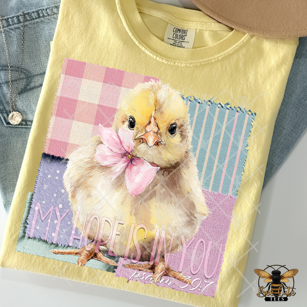 Yellow t-shirt with a chick graphic and text on a denim surface