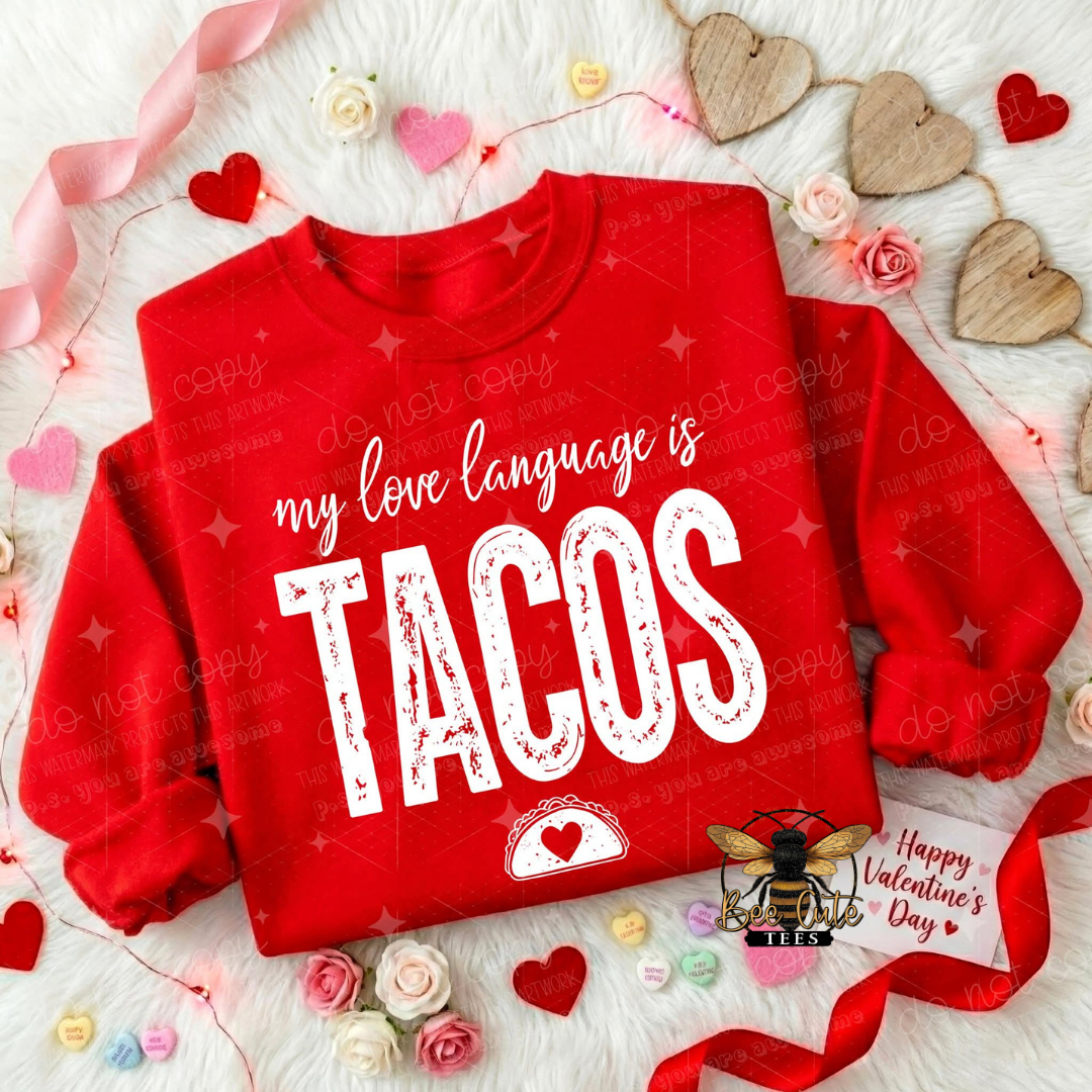 Red sweatshirt with 'my love language is TACOS' text on a decorative background with hearts and flowers.