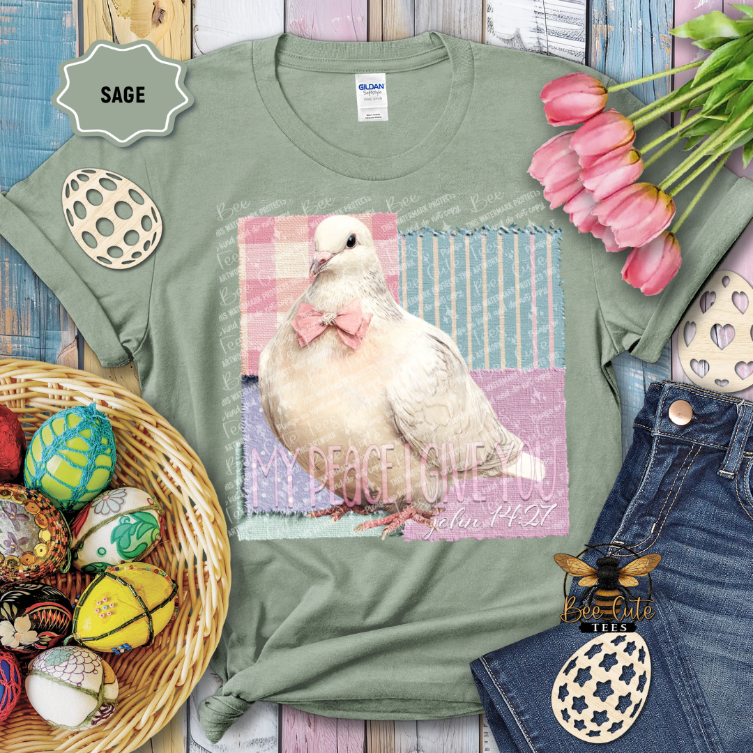 Green t-shirt with a dove graphic and text, surrounded by Easter decorations on a wooden surface.