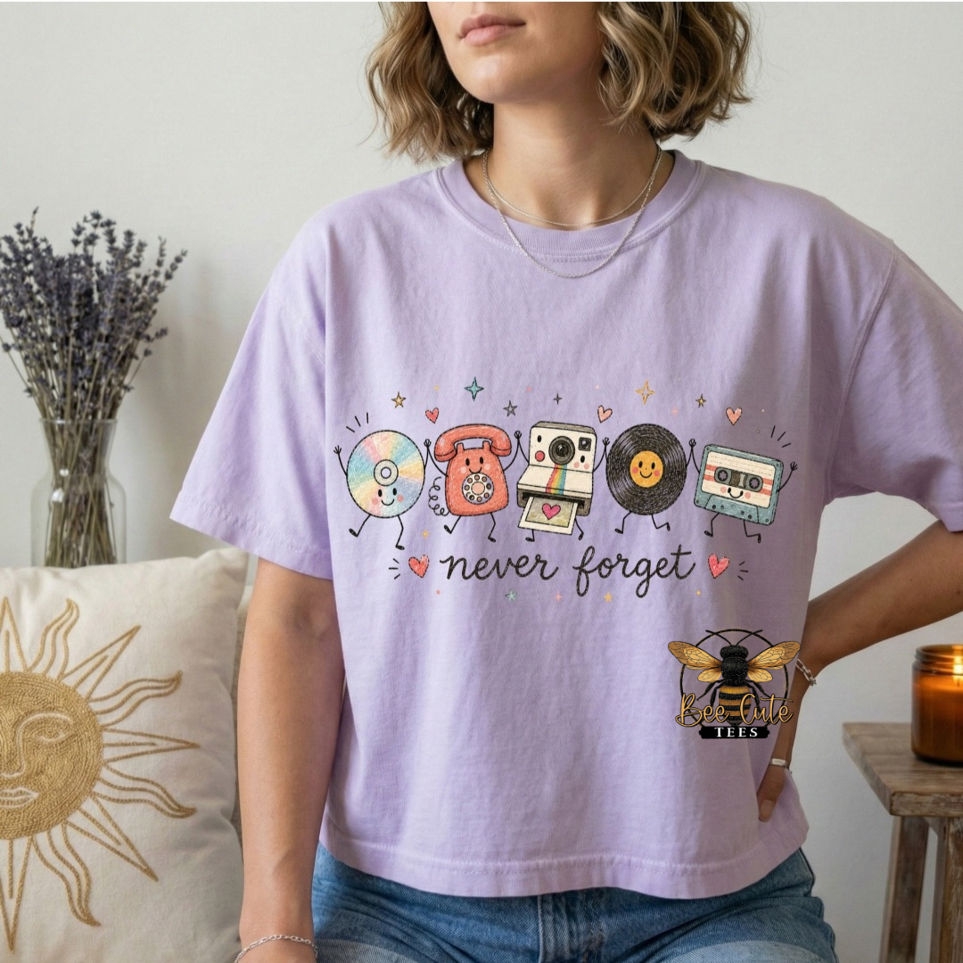 A woman wearing a lavender graphic t-shirt with retro cassette tape and CD designs, paired with blue jeans, in a cozy indoor setting with a sun pillow and dried lavender.