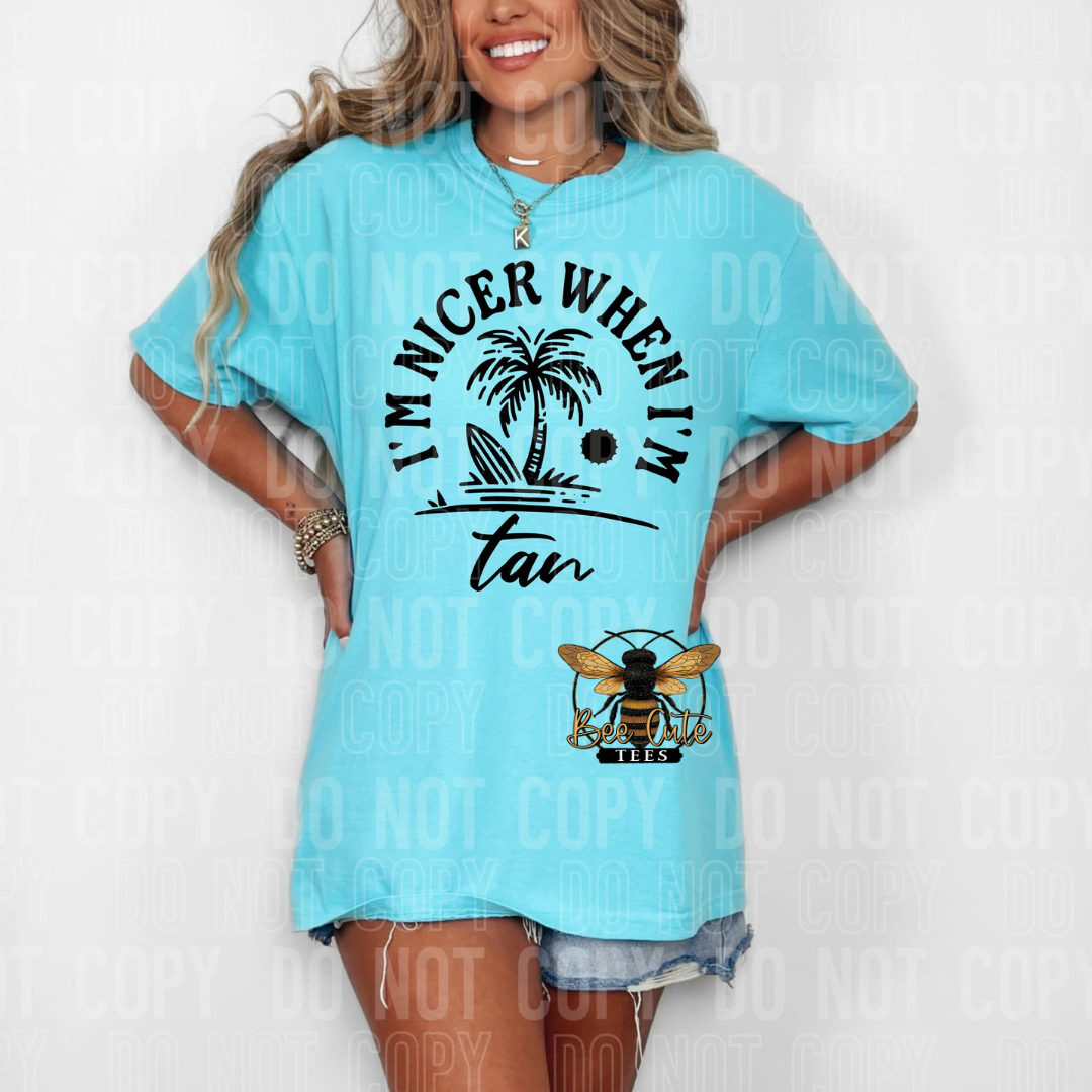 Woman wearing a light blue t-shirt with a tropical design and text.