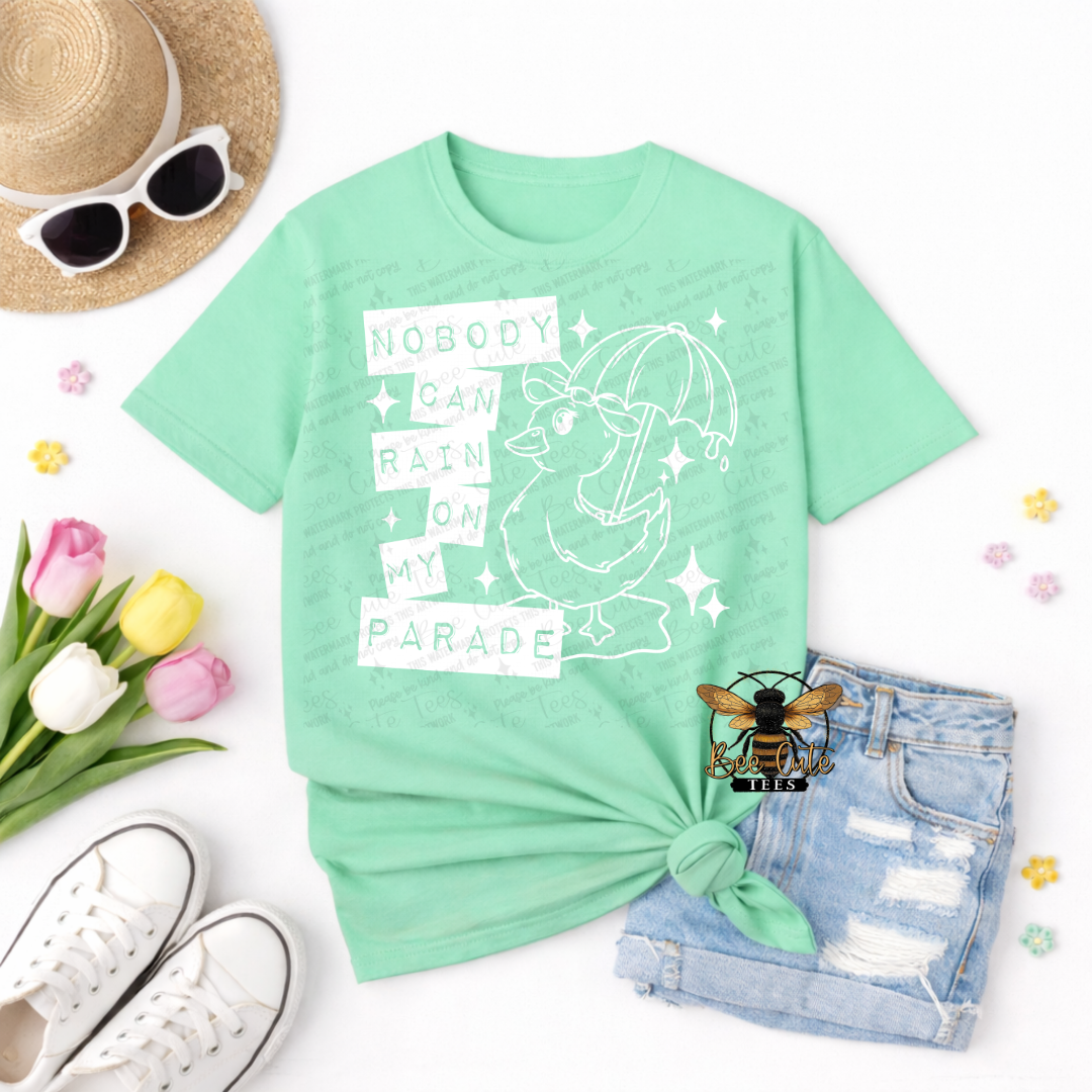 Mint green t-shirt with graphic design and text, sunglasses, hat, tulips, and shorts on a white background