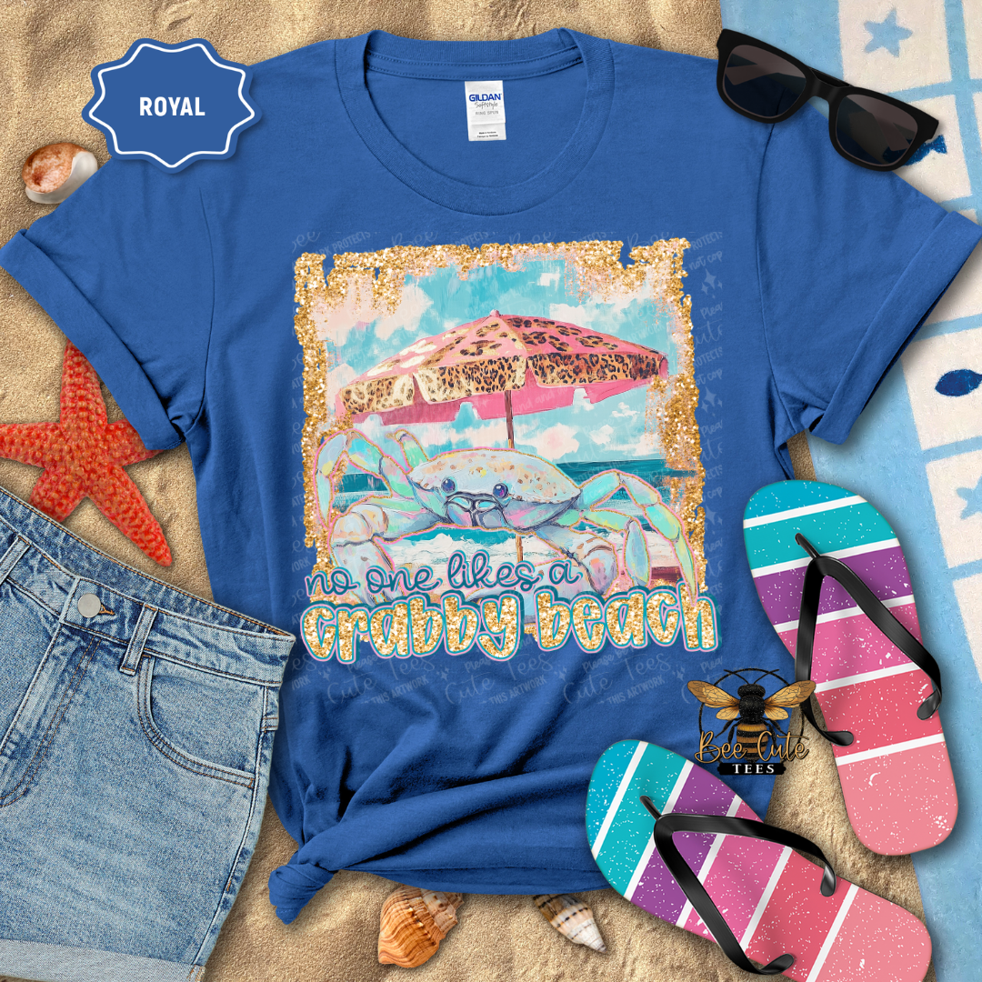 Blue t-shirt with beach-themed design and accessories on a textured surface