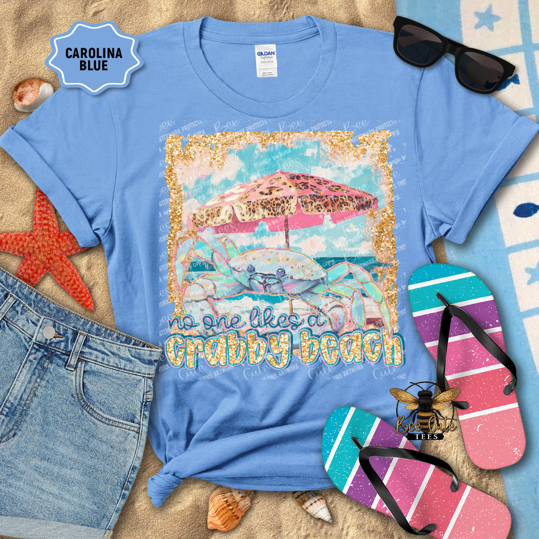 Blue t-shirt with beach graphic and text, surrounded by flip-flops, sunglasses, and beach accessories.