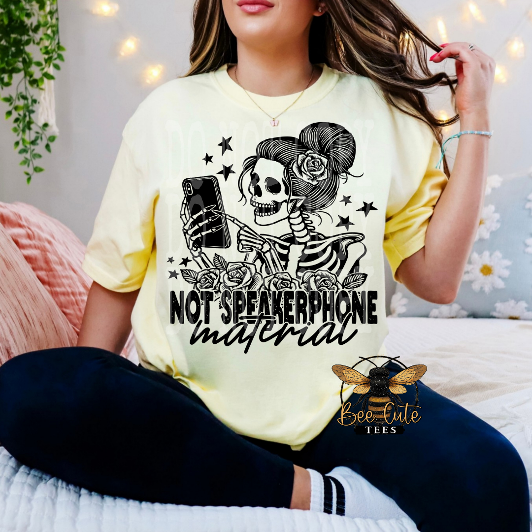 Person wearing a yellow t-shirt with a skeleton design and text, sitting on a bed.
