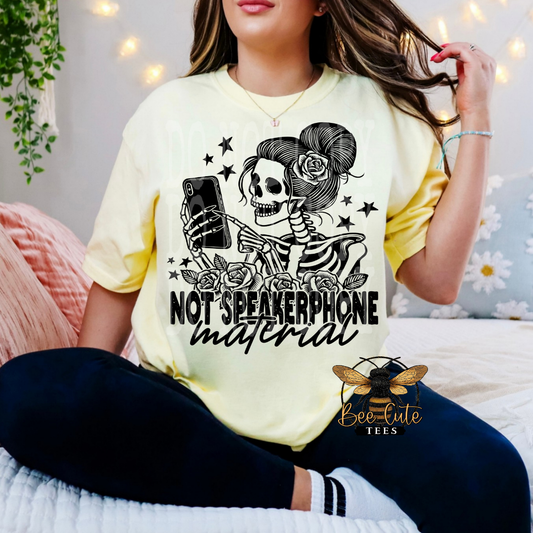 Person wearing a yellow t-shirt with a skeleton design and text, sitting on a bed.