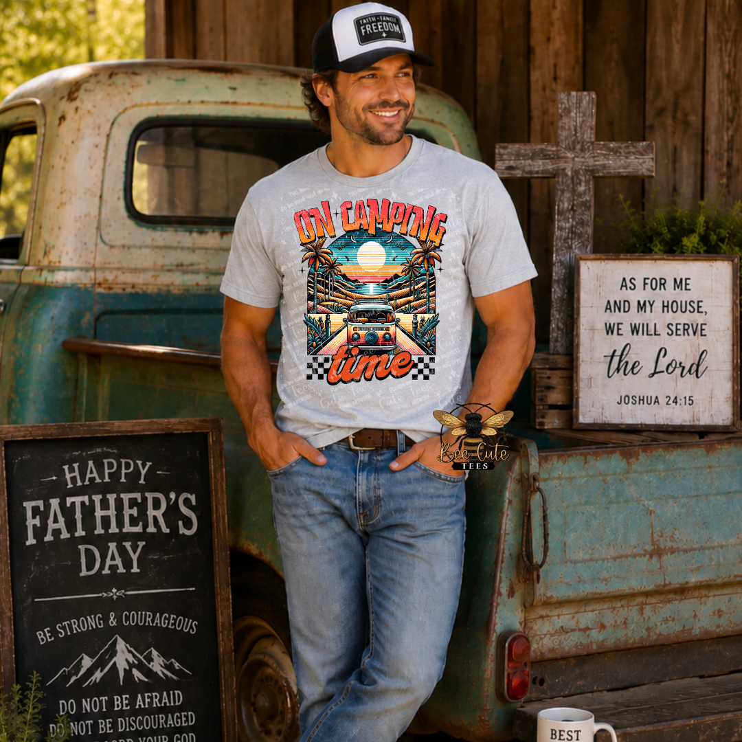 Man wearing a 'On Camping Time' t-shirt standing next to an old truck with rustic decor.