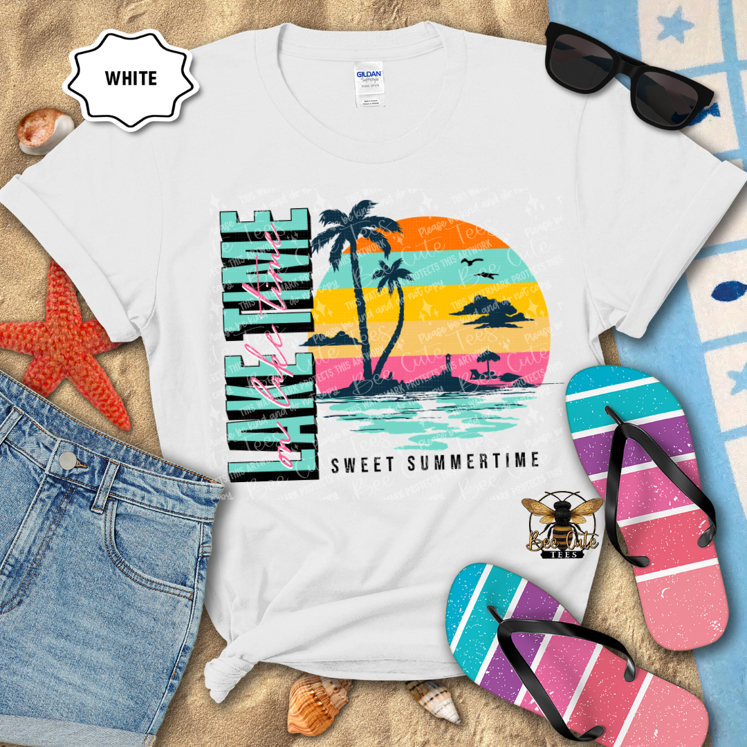 White t-shirt with a colorful 'Sweet Summertime' design, sunglasses, flip-flops, and denim shorts on a sandy background.
