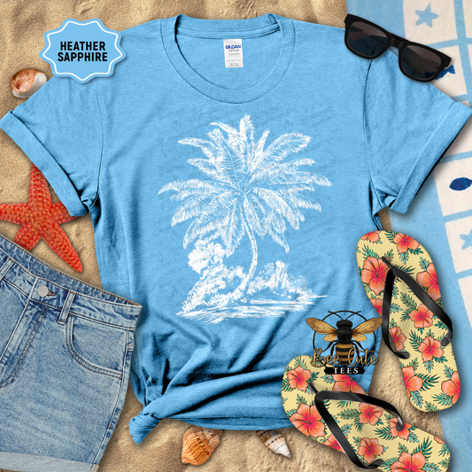 Blue t-shirt with palm tree design, sunglasses, flip-flops, and beach accessories on a sandy background.
