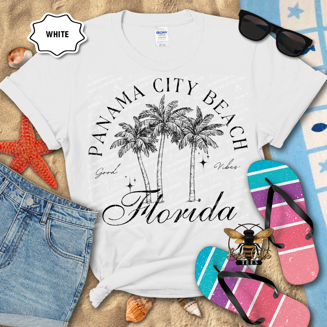 White t-shirt with 'Panama City Beach, Florida' design on a beach-themed background with flip-flops and sunglasses.