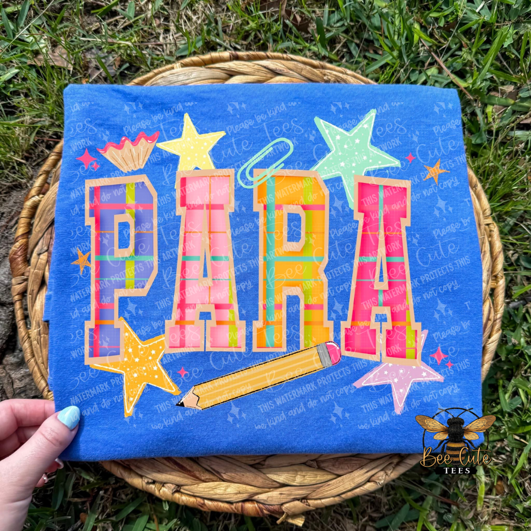 Colorful ' PARA' design on a blue background held by a hand outdoors.