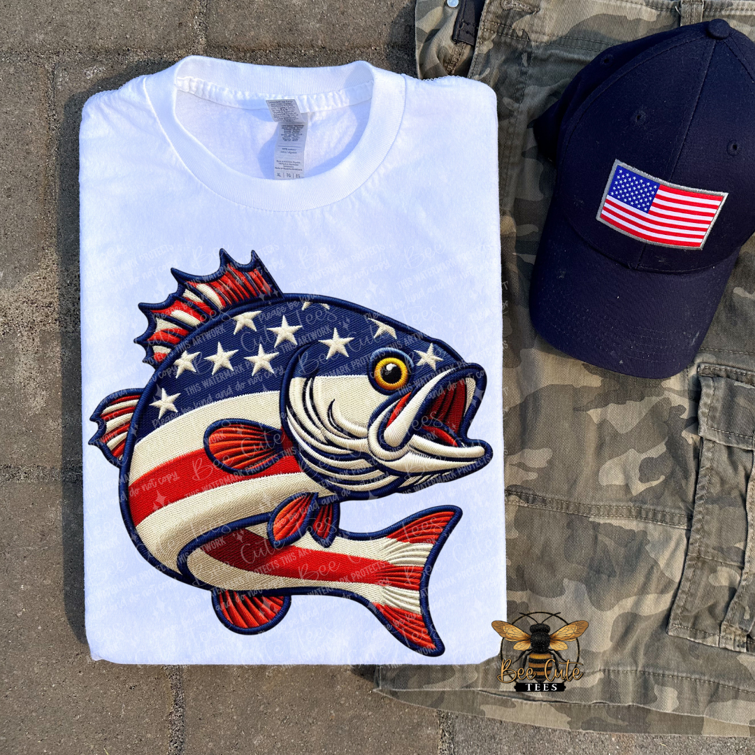 White t-shirt with fish design and American flag, navy cap with American flag, camouflage pants.