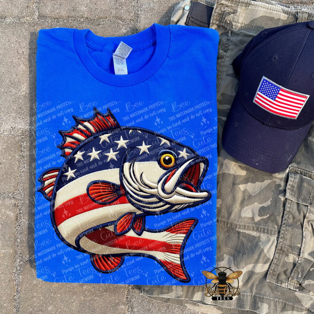 Blue t-shirt with fish design, cap, and camouflage shorts on a concrete surface