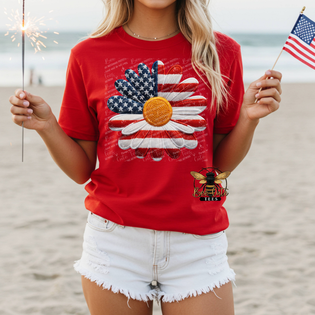 Person wearing a red t-shirt with a graphic design on a beach