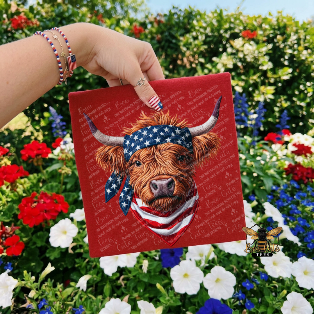 Hand holding a red card with a cow wearing an American flag bandana against a floral background