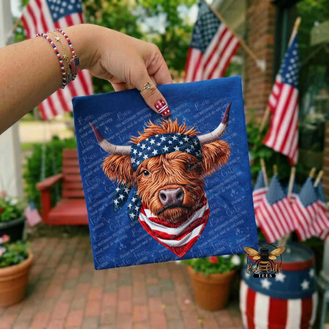 Hand holding a small blue flag with a cow wearing an American flag bandana, surrounded by American flags.
