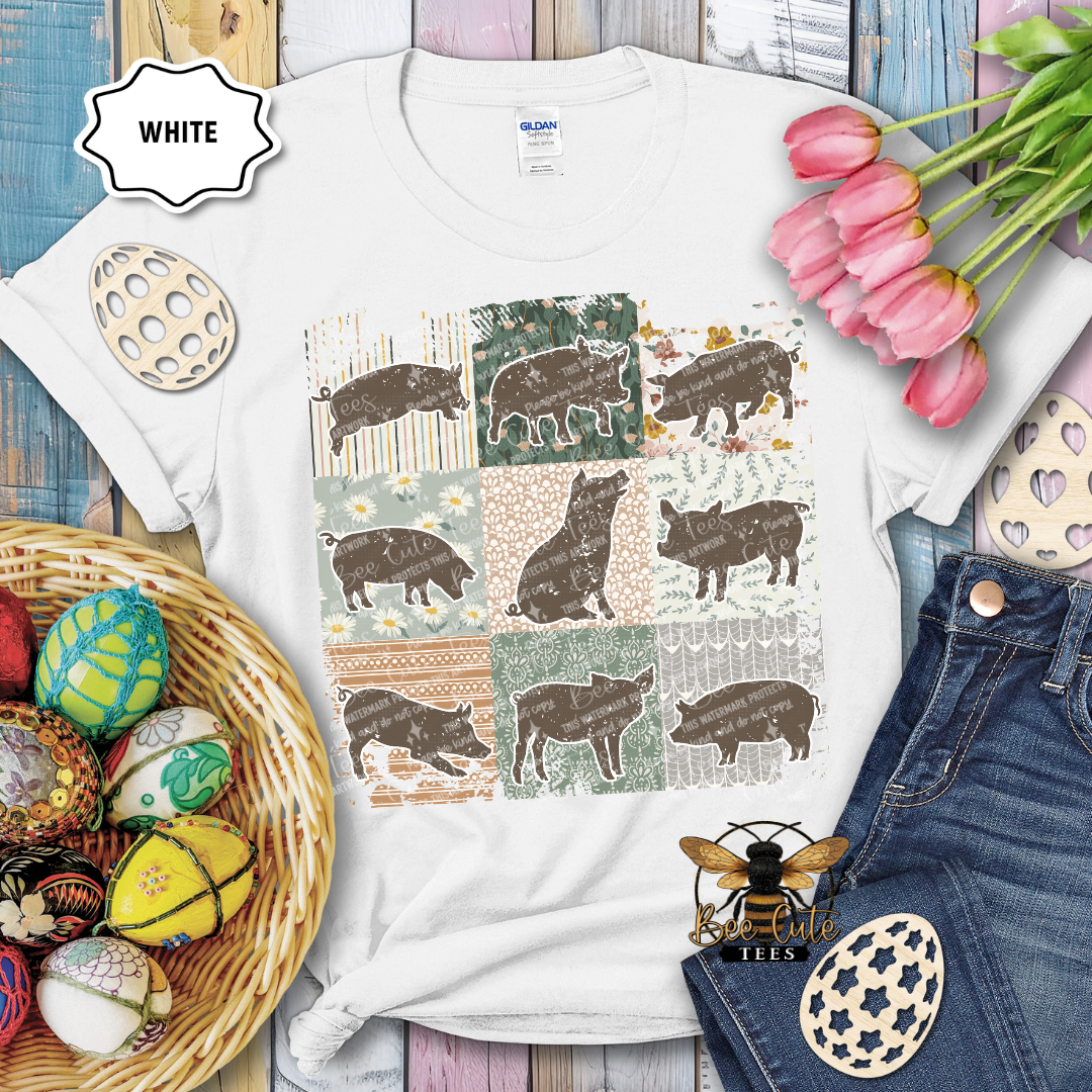 White t-shirt with pig pattern on a wooden surface with Easter decorations.