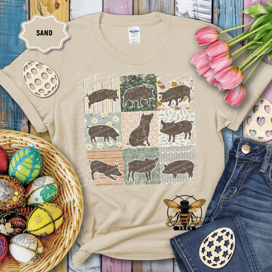Beige t-shirt with pig pattern, surrounded by decorative items on a wooden surface.