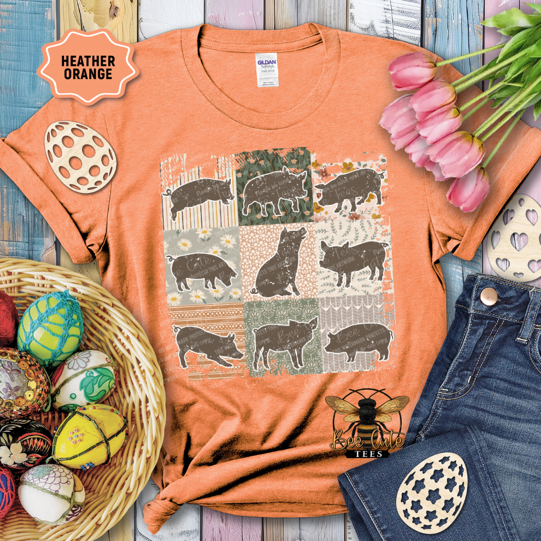 Orange t-shirt with pig pattern, surrounded by decorative items on a wooden surface.