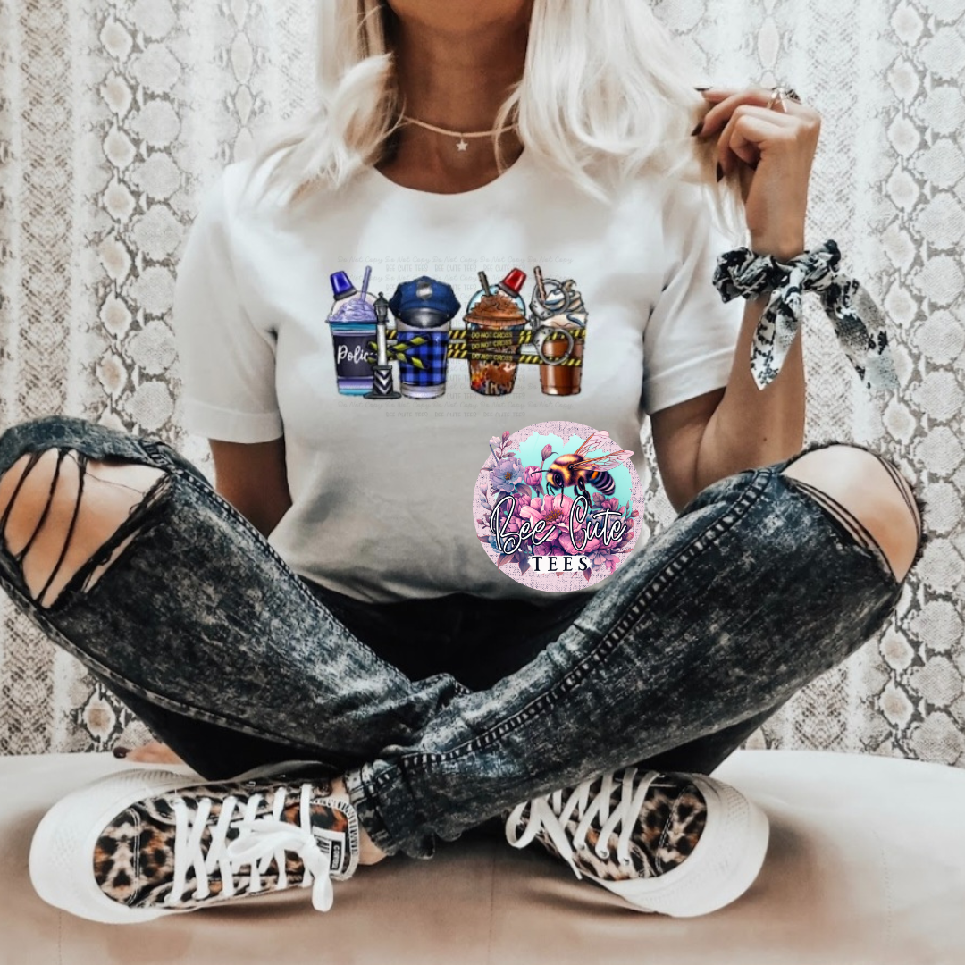 Person wearing a white t-shirt with graphic designs and ripped jeans sitting on a patterned floor.