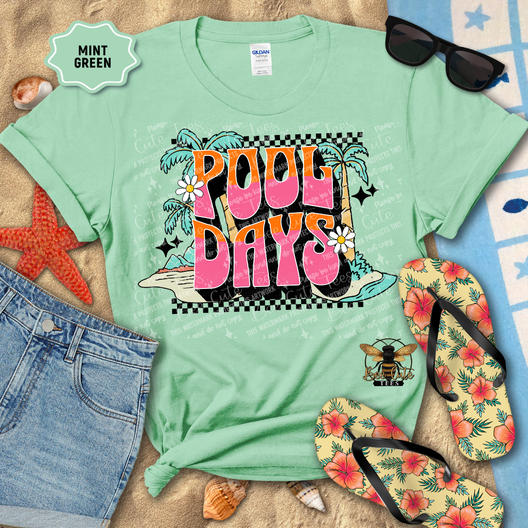 Mint green t-shirt with 'Pool Days' design on a beach-themed background with sunglasses, flip-flops, and starfish.