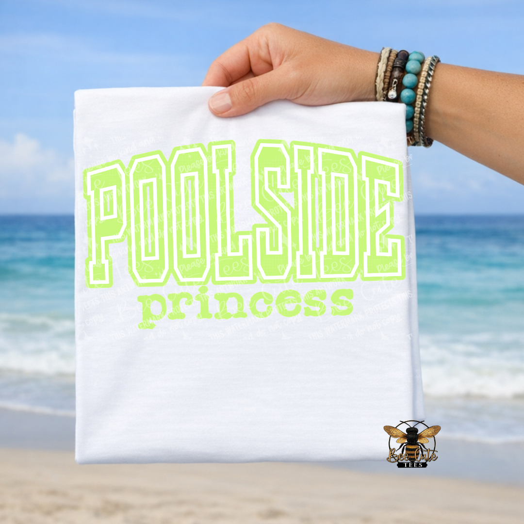 Hand holding a white t-shirt with 'Poolside princess' text against a beach background
