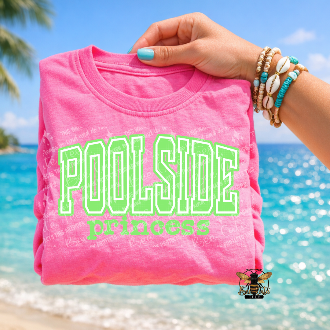 Pink t-shirt with 'POOLSIDE princess' text held by a hand against a beach background