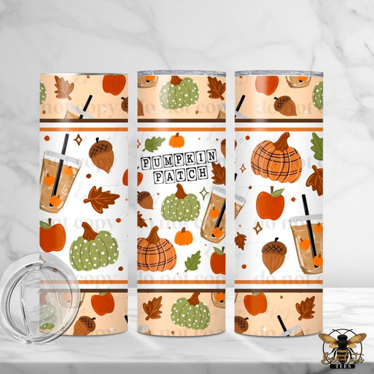 Three insulated tumblers with a fall 'Pumpkin Patch' pattern are displayed on a white marble surface with a clear lid in the foreground. The pattern features orange pumpkins, green striped pumpkins, acorns, leaves, and iced coffee illustrations on a cream background.