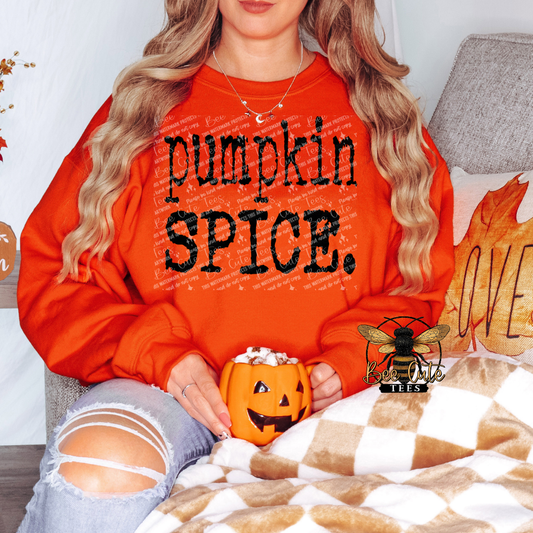 Person wearing an orange sweatshirt with 'pumpkin spice' text, holding a pumpkin mug, sitting on a couch.