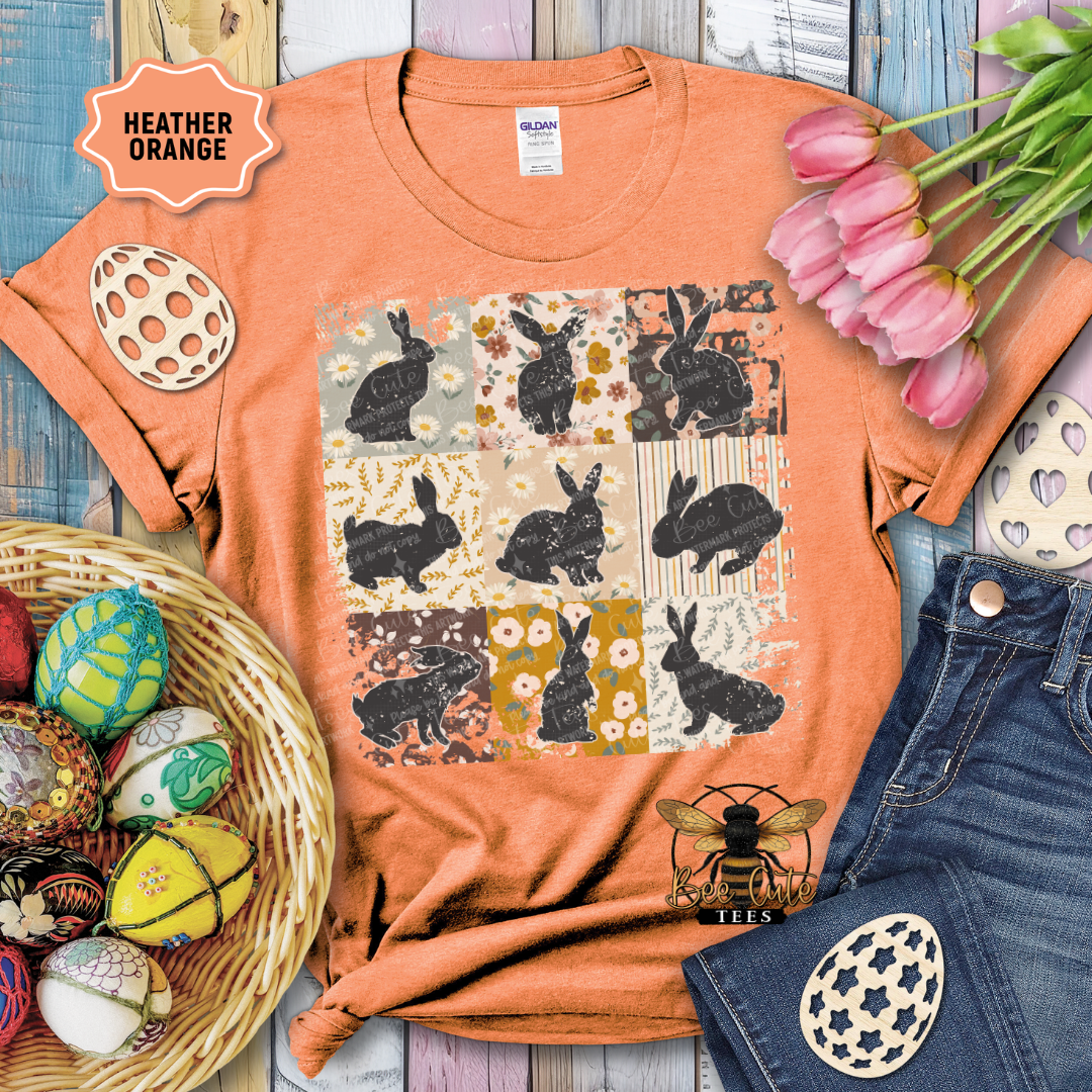 Orange t-shirt with bunny pattern, surrounded by Easter decorations on a wooden surface.