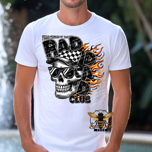 Man wearing a white graphic tee featuring a skull in sunglasses and a checkered cap with flames in the background and the phrase “Proud Member of the Rad Dad Club” in bold distressed lettering.
