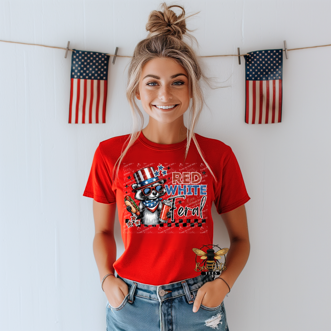Woman wearing a red t-shirt with a graphic design, standing in front of a white wall with American flags.