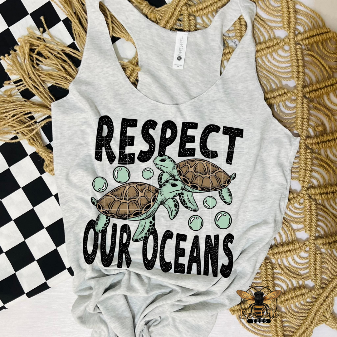 Gray tank top with turtles and 'Respect Our Oceans' text on a textured surface.