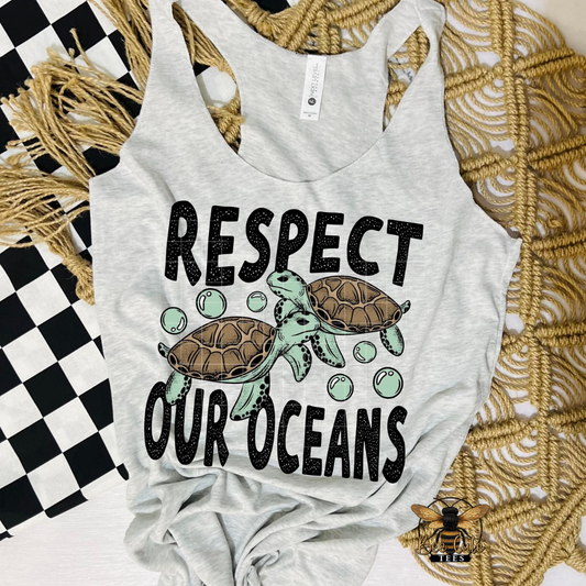 Gray tank top with turtles and 'Respect Our Oceans' text on a textured surface.