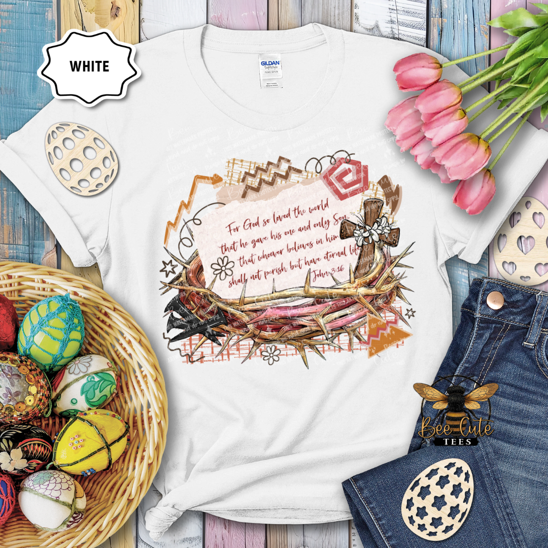White t-shirt with religious design, Easter eggs, and tulips on a wooden surface