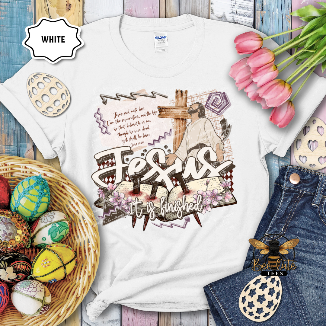White t-shirt with religious design featuring a cross and text, surrounded by Easter decorations.
