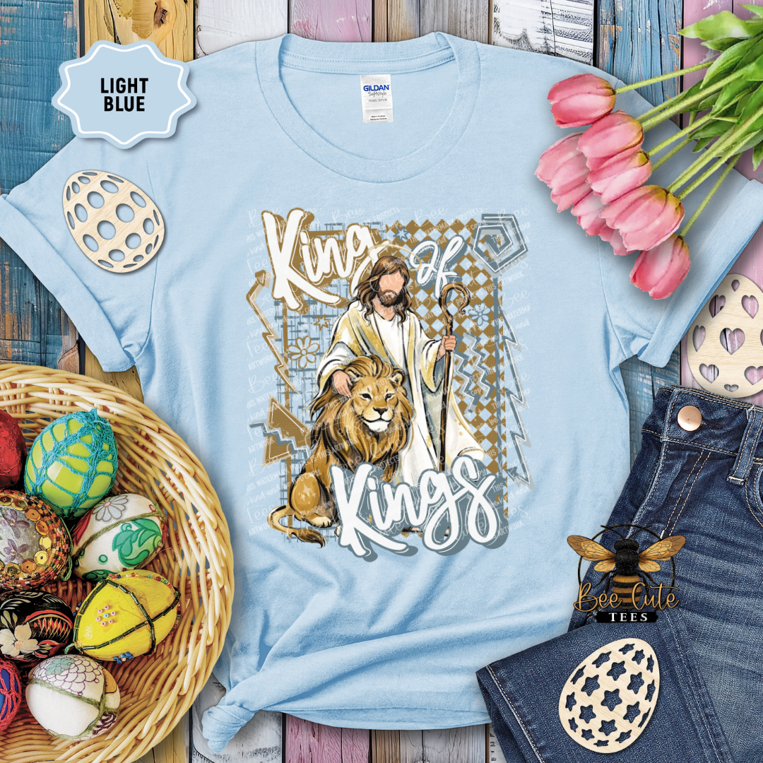 Light blue t-shirt with a graphic design featuring a lion and text, surrounded by Easter decorations.