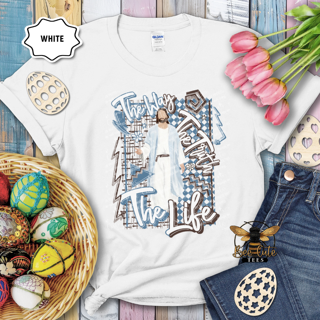 White t-shirt with graphic design featuring a person and text, surrounded by Easter decorations on a wooden surface.